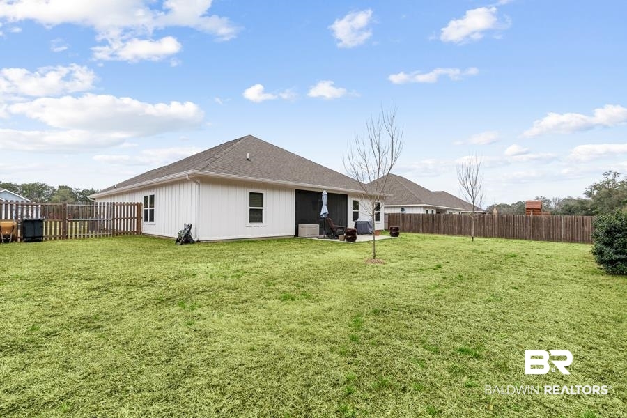697 Calibre Street Fairhope, AL 36532 - Photo 17 of 18 Back of property with a patio area, a fenced backyard, and a shingled roof