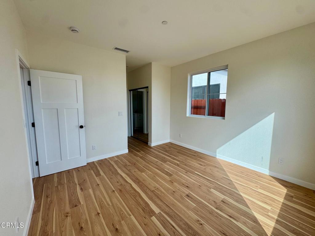 1170 West 1st Street Oxnard, CA 93030 - Photo 16 of 27 a view of an empty room with wooden floor and a window