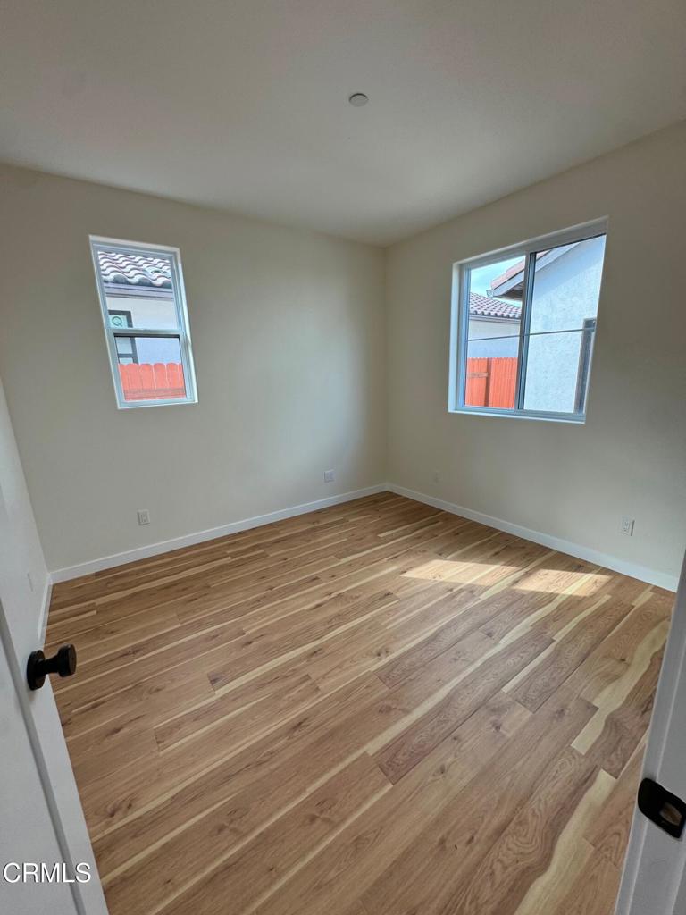 1170 West 1st Street Oxnard, CA 93030 - Photo 19 of 27 a view of a room with wooden floor and window