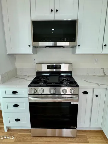 a kitchen with granite countertop white cabinets and white appliances