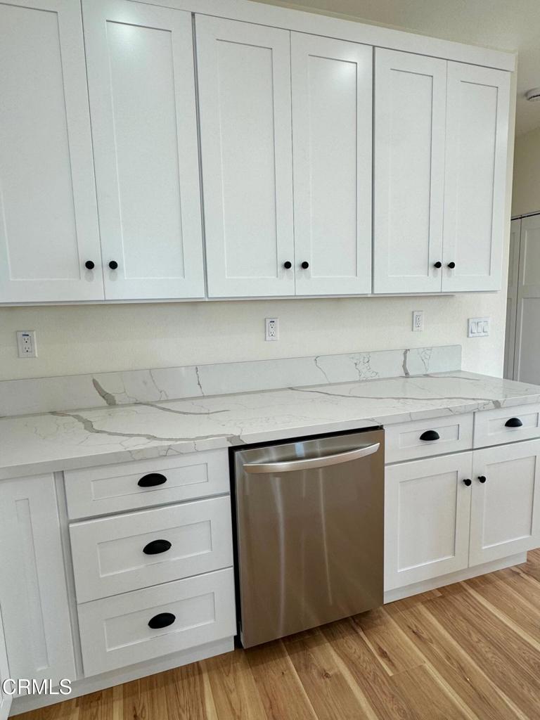 1170 West 1st Street Oxnard, CA 93030 - Photo 23 of 27 a kitchen with granite countertop white cabinets and white appliances