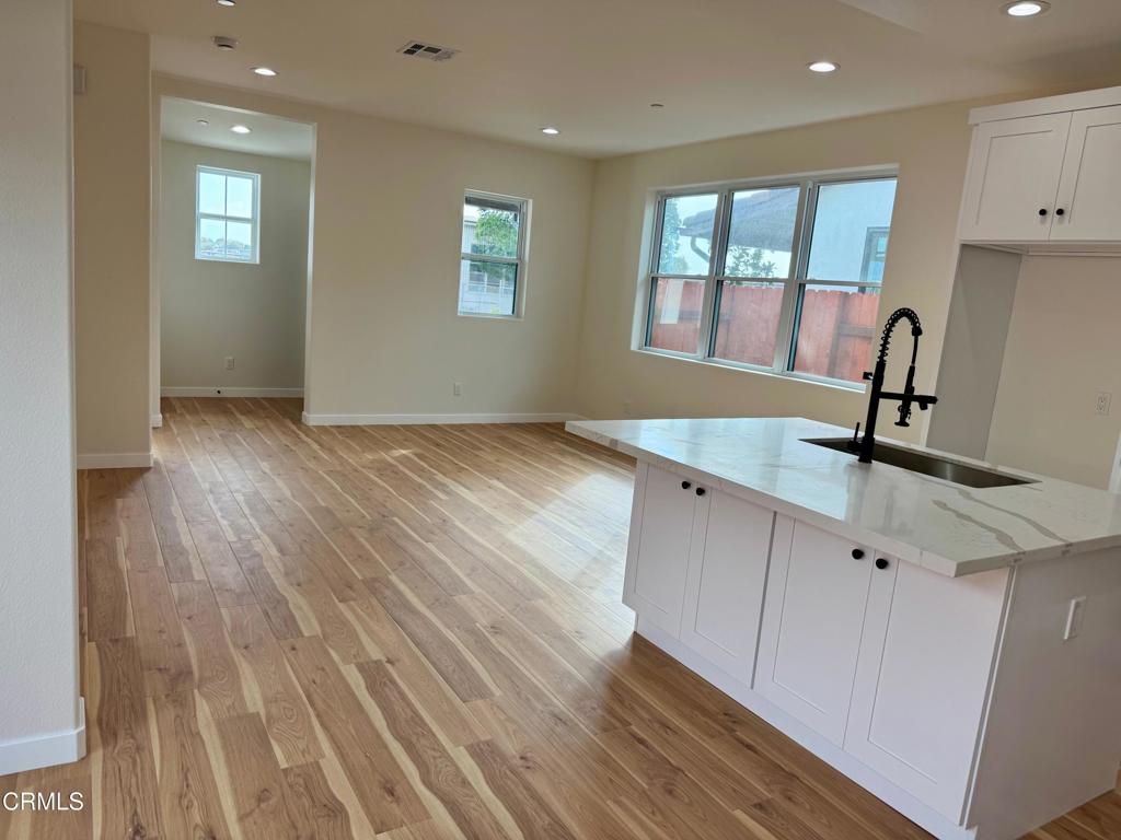 1170 West 1st Street Oxnard, CA 93030 - Photo 7 of 27 a view of hallway with window and wooden floor