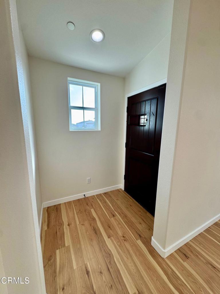 1170 West 1st Street Oxnard, CA 93030 - Photo 8 of 27 an empty room with wooden floor and entrance