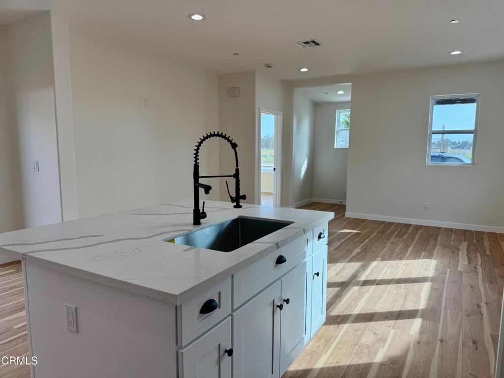 1170 West 1st Street Oxnard, CA 93030 - Photo 9 of 27 a kitchen with a sink and a refrigerator