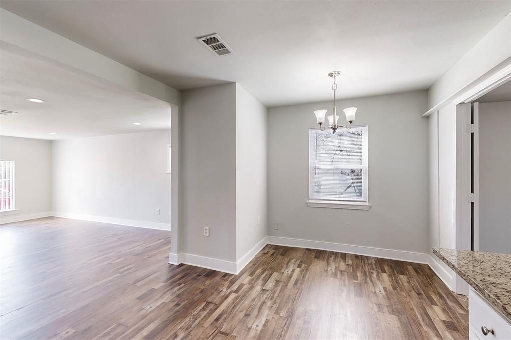 2667 Custer Drive Dallas, TX 75216 - Photo 12 of 33 an empty room with wooden floor chandelier and windows