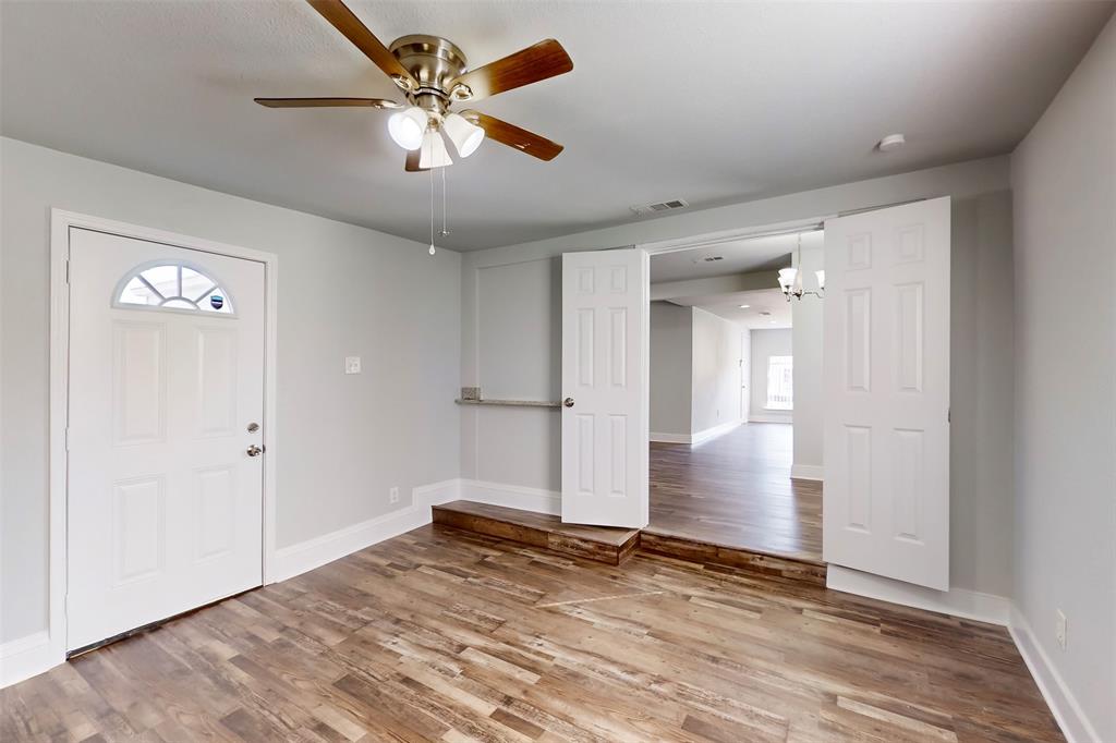 2667 Custer Drive Dallas, TX 75216 - Photo 15 of 33 an empty room with wooden floor and ceiling fan