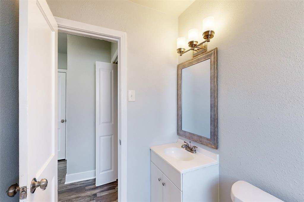 2667 Custer Drive Dallas, TX 75216 - Photo 27 of 33 a bathroom with a sink vanity mirror and toilet