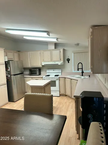 a kitchen with a sink a refrigerator and cabinets