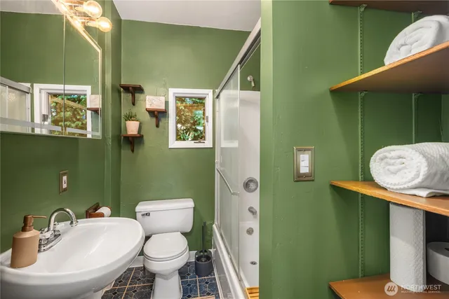 a bathroom with a toilet sink and mirror