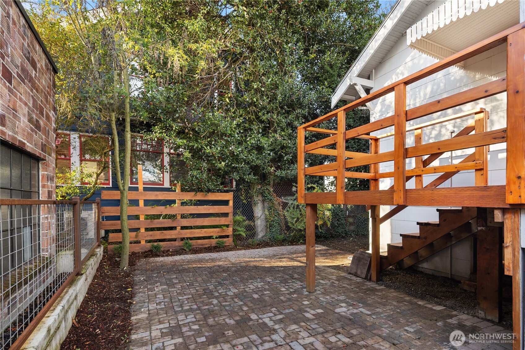 151 North 77th Street Seattle, WA 98103 - Photo 23 of 27 a backyard of a house with wooden fence and trees