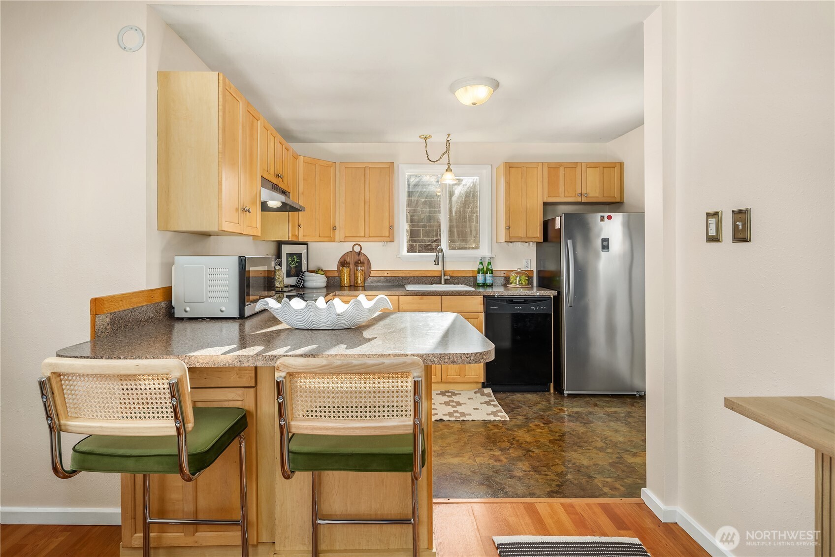 151 North 77th Street Seattle, WA 98103 - Photo 9 of 27 a kitchen with stainless steel appliances kitchen island granite countertop a refrigerator and a stove top oven