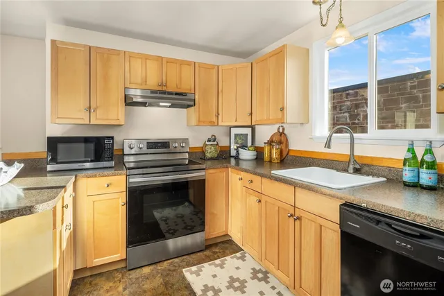 a kitchen with stainless steel appliances granite countertop a stove a sink and a granite counter tops