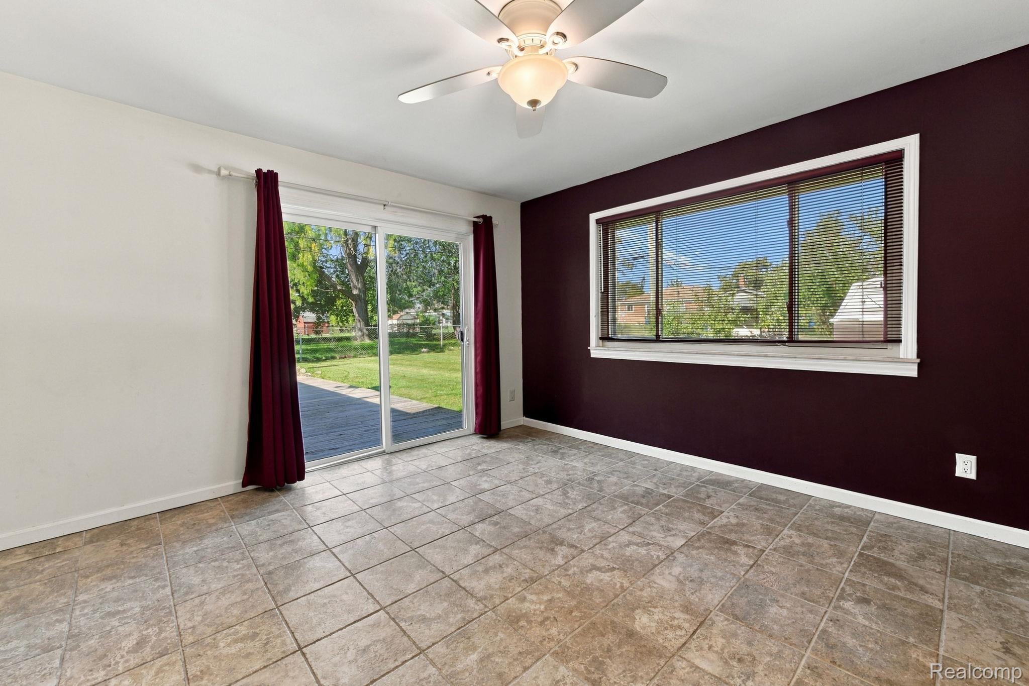 13265 12 Mile Road Warren, MI 48088 - Photo 22 of 33 Tile flooring, ceiling fan with light fixture, large window, and sliding glass door leading to an outdoor patio