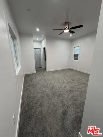 en empty room with ceiling fan and window