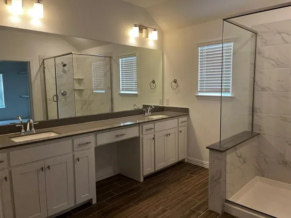 a spacious bathroom with double sink and a mirror