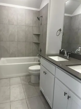 a bathroom with a granite countertop toilet a sink and bathtub