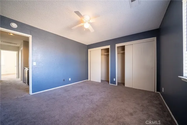 an empty room with windows and closet