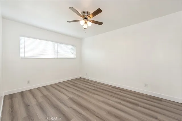 an empty room with a window and a fan