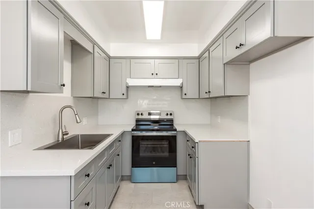 a kitchen with stainless steel appliances granite countertop a sink stove and cabinets