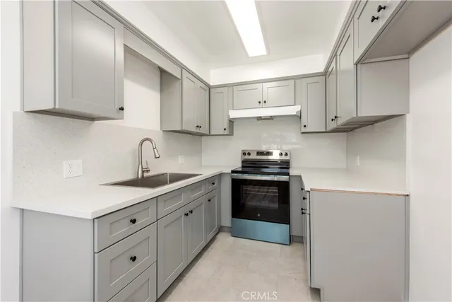 a kitchen with stainless steel appliances granite countertop white cabinets sink and window