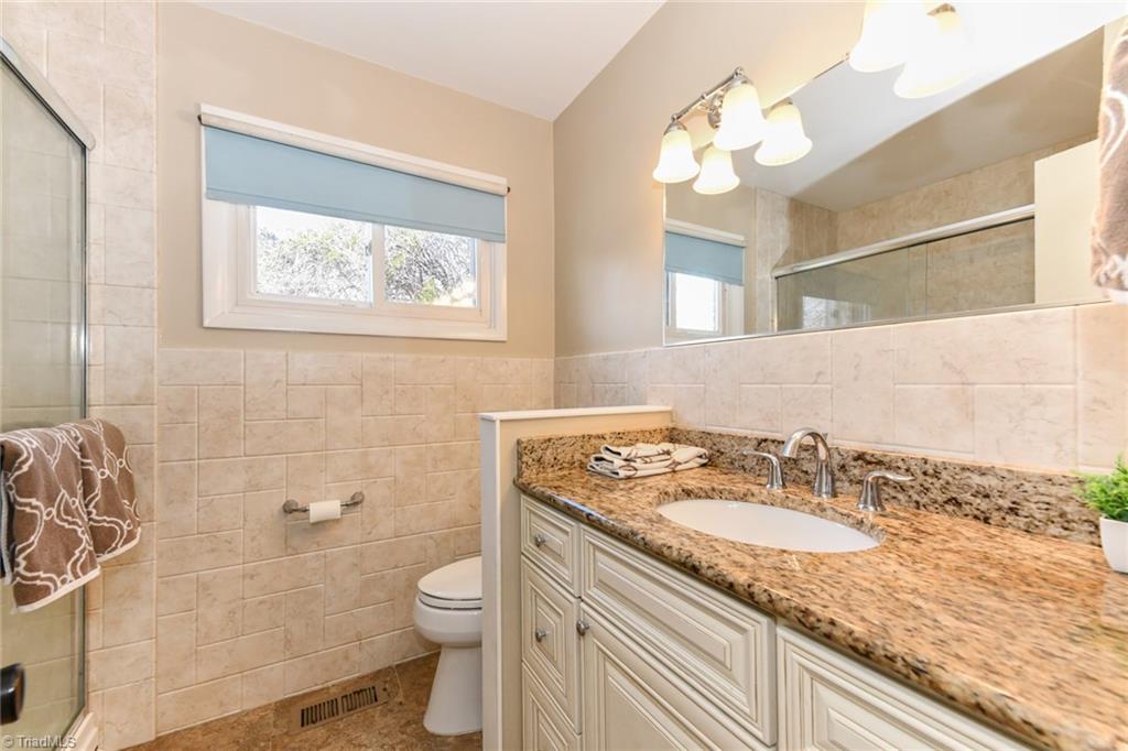2206 Springhill Road Greensboro, NC 27403 - Photo 17 of 27 Lovely updated bath with granite high countertops, tile and walk-in shower