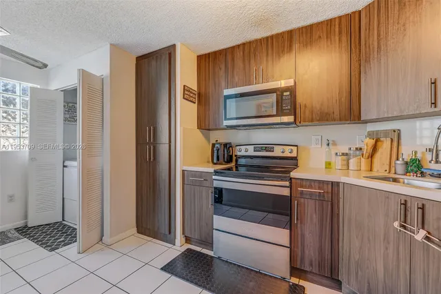 a kitchen with stainless steel appliances granite countertop a refrigerator and a stove top oven