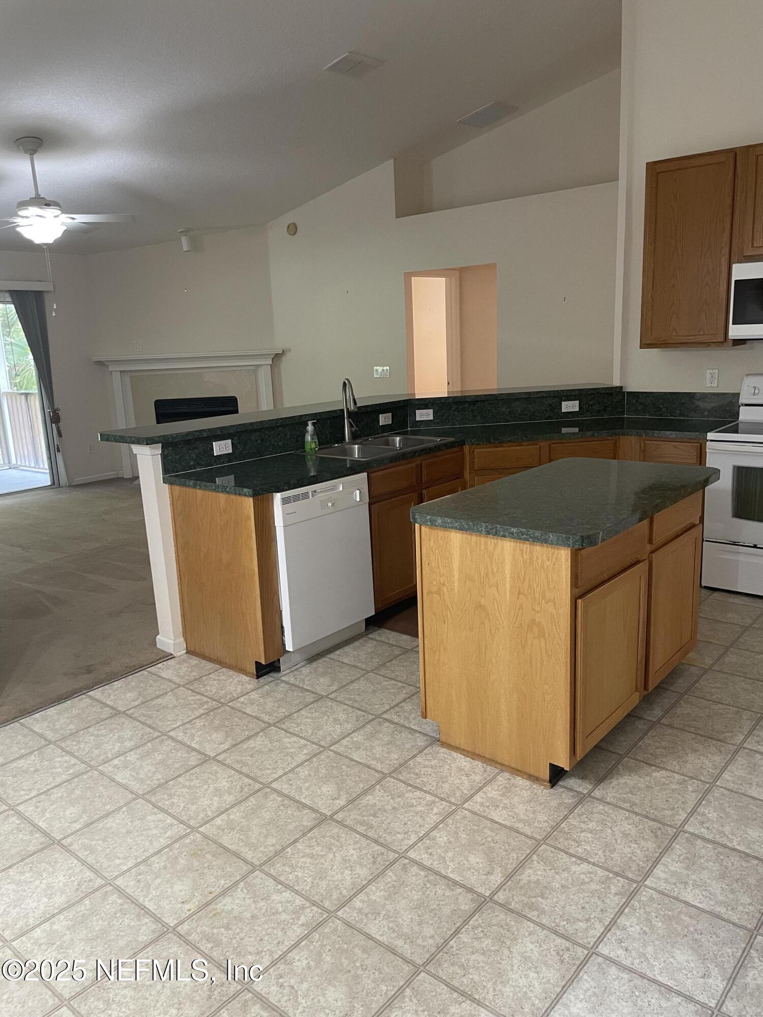 12551 Arrowleaf Lane Jacksonville, FL 32225 - Photo 2 of 14 a kitchen with stainless steel appliances a sink a stove a microwave a counter top space and cabinets