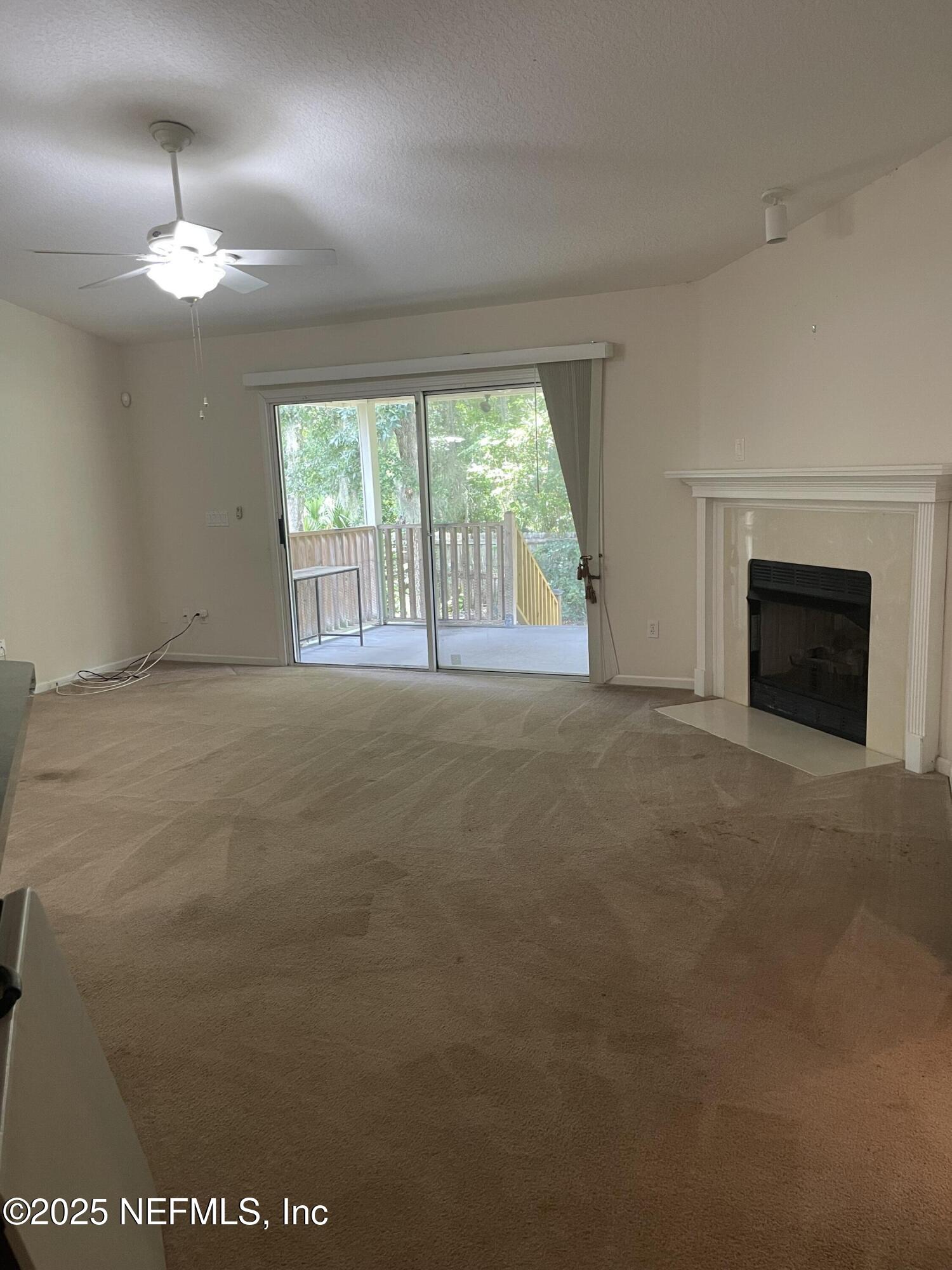 12551 Arrowleaf Lane Jacksonville, FL 32225 - Photo 5 of 14 en empty room with windows and fireplace
