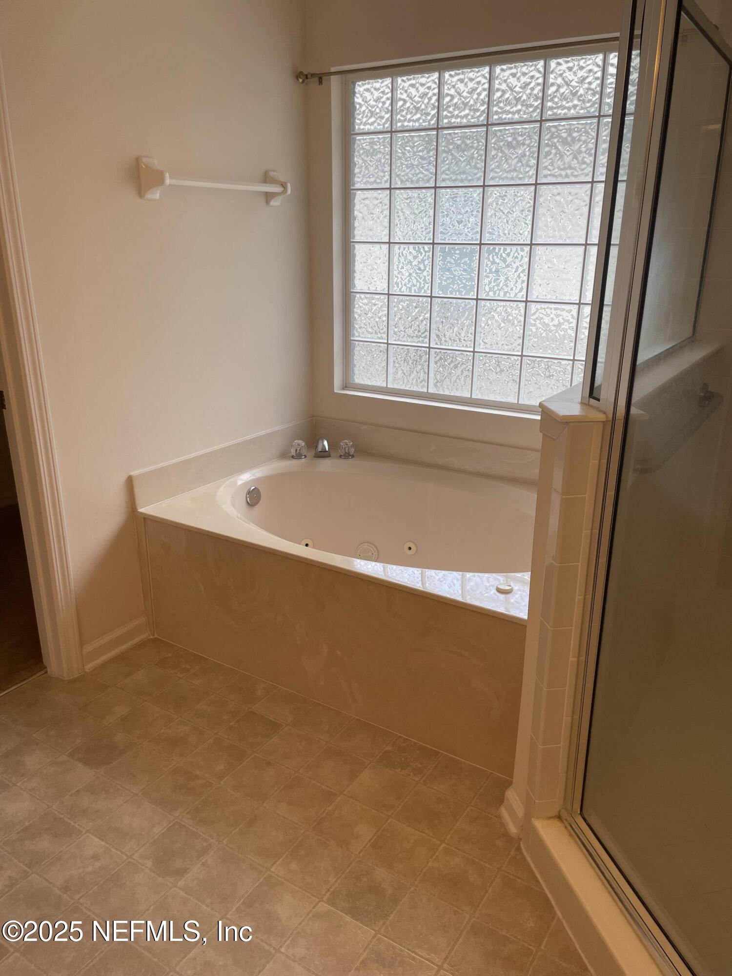 12551 Arrowleaf Lane Jacksonville, FL 32225 - Photo 10 of 14 a bath tub sitting in a bathroom next to a window