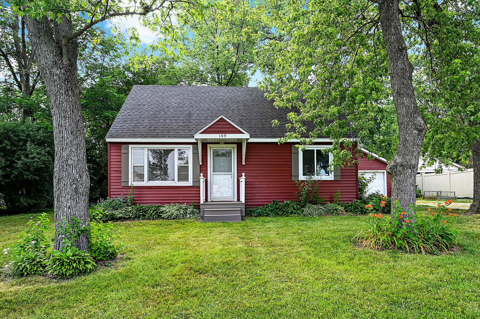 a front view of a house with a yard and fence