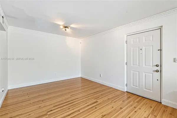 a view of an empty room with wooden floor