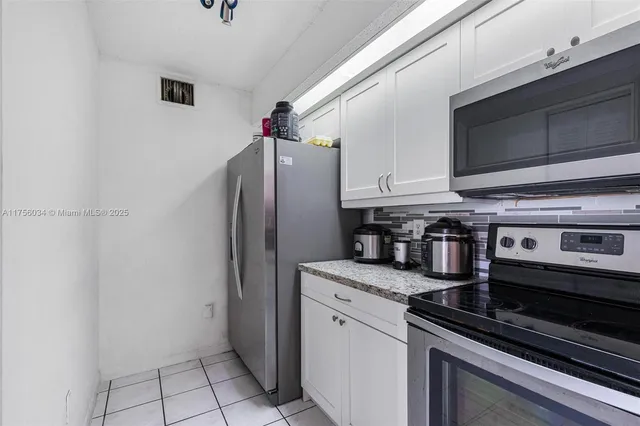a kitchen with stainless steel appliances granite countertop a refrigerator and a stove top oven