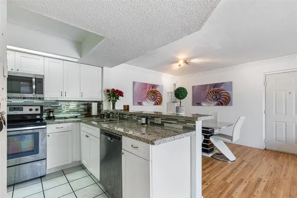 a kitchen with stainless steel appliances granite countertop a stove and white cabinets