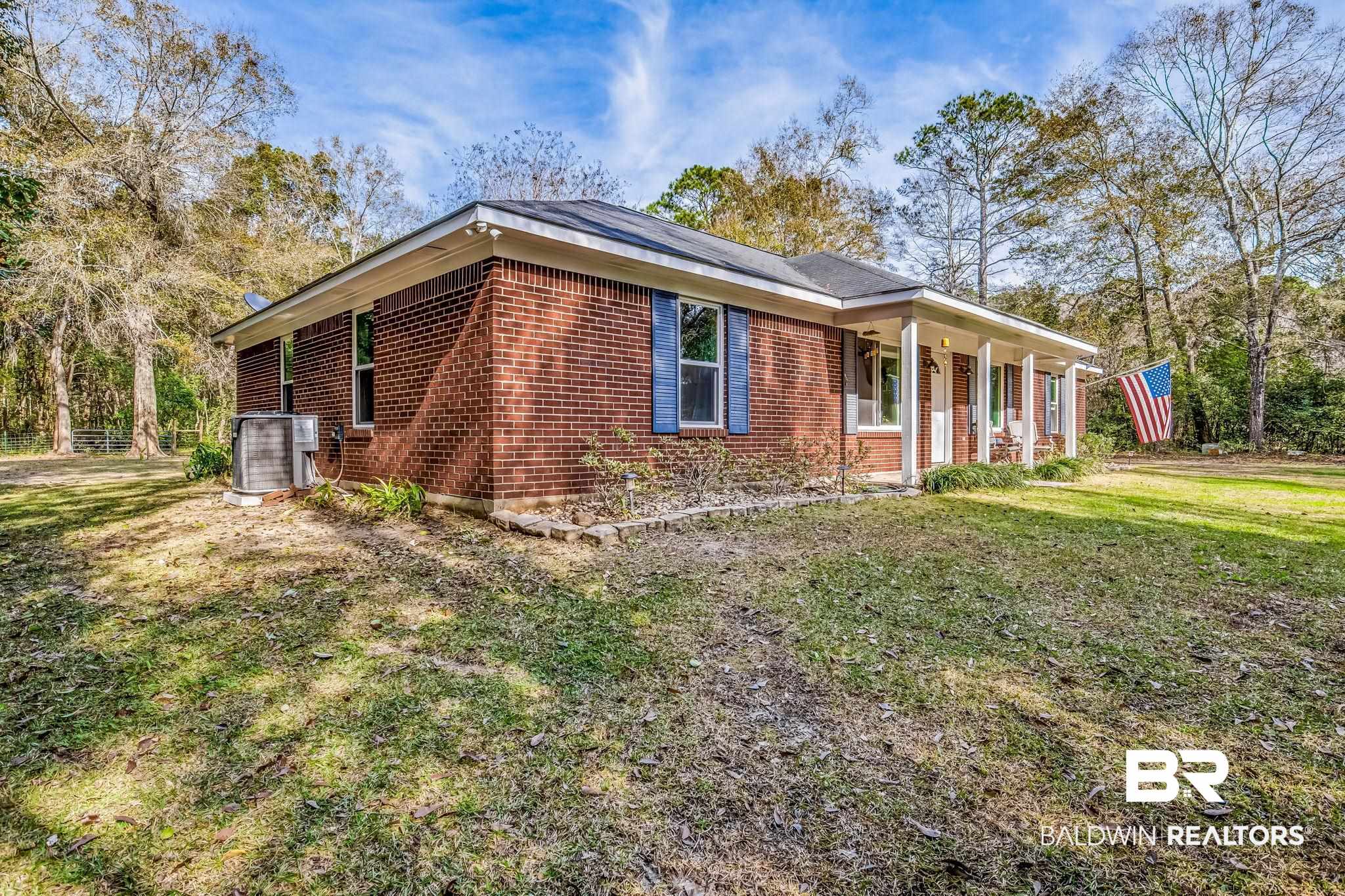12199 Bay Road West Foley, AL 36535 - Photo 2 of 62 View of side of property featuring brick siding, a yard, and a porch