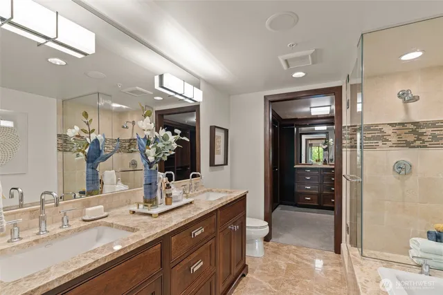 a bathroom with a granite countertop sink mirror and shower