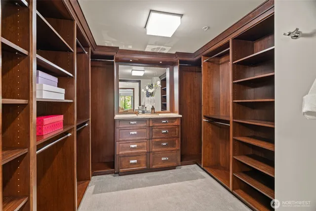 a view of walk in closet with clothes and shoes