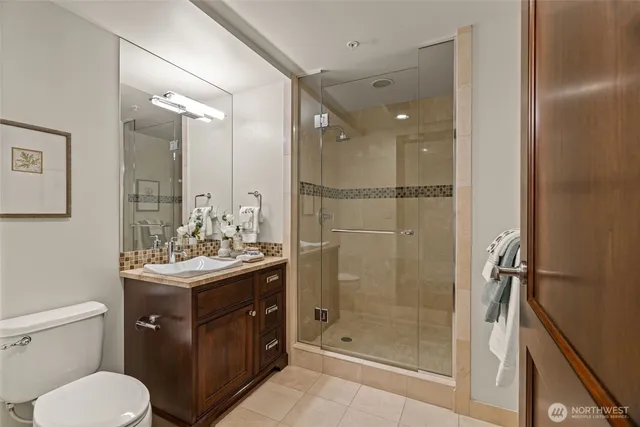 a bathroom with a toilet a sink a mirror and shower