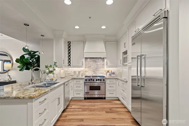 a kitchen with stainless steel appliances granite countertop a refrigerator and a sink