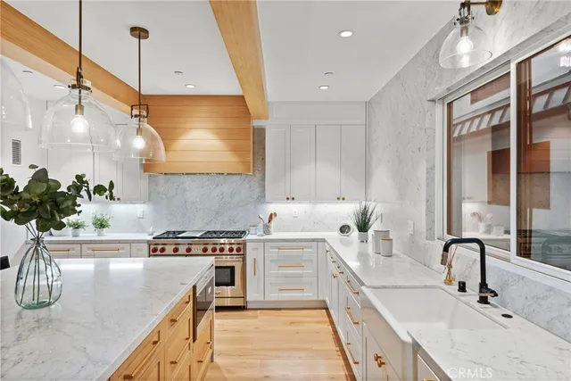 a kitchen with stainless steel appliances a sink a stove and a wooden floor