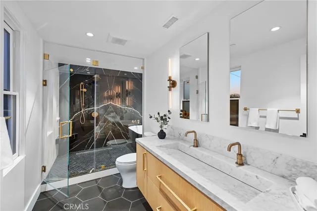 a bathroom with a sink a toilet and shower