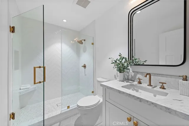a bathroom with a granite countertop sink toilet and shower