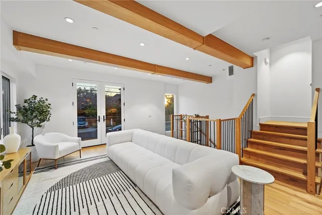 a living room with furniture a chandelier and a dining table