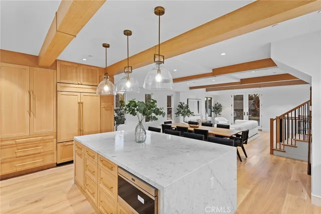 a dining hall with stainless steel appliances kitchen island granite countertop a sink and cabinets
