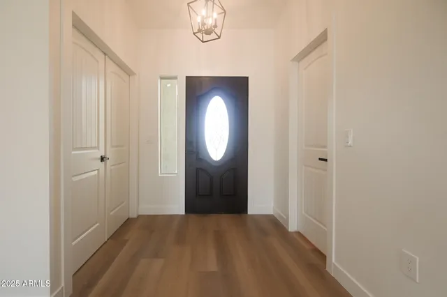 a view of a room with wooden floor mirror and window