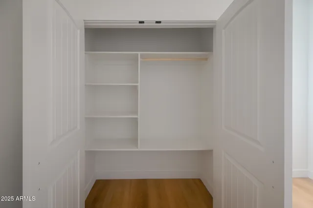 a view of walk in closet with empty racks