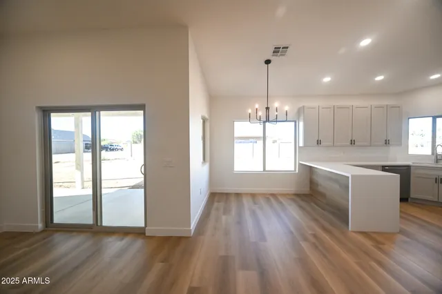 a large kitchen with hardwood floor a sink and appliances