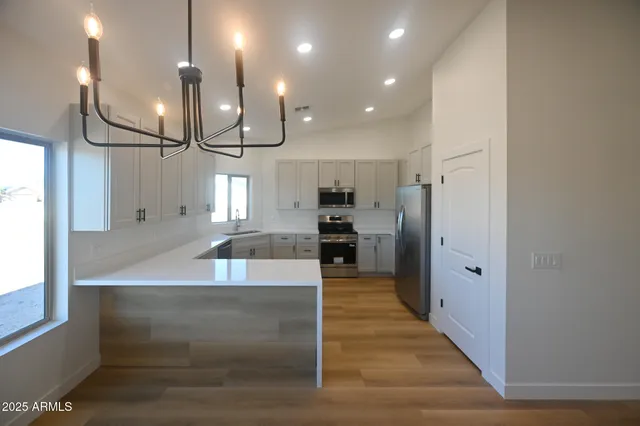 an open kitchen with a refrigerator and a fireplace