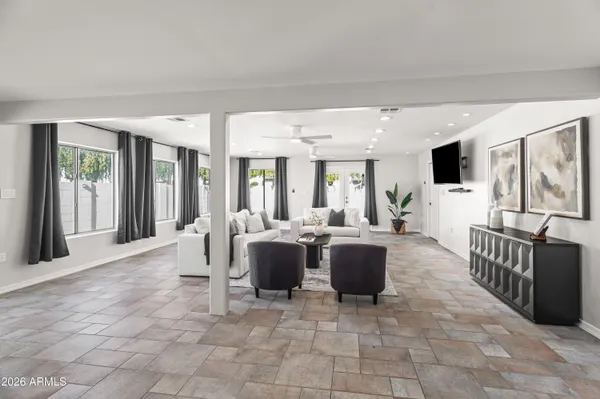 a living room with furniture a large window and a flat screen tv