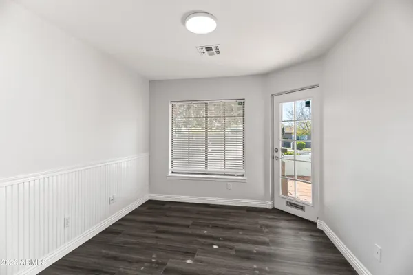 an empty room with wooden floor and windows