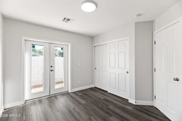 an empty room with wooden floor and windows